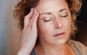 A woman is experiencing a headache