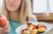 A plateful of carbs and a woman holding an apple