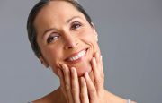 Mature woman smiling and touching her face