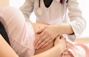 Doctor examining a pregnant women's stomach