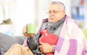 A man is holding a hot water bottle in his hands