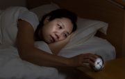 Woman checking her alarm clock in the middle of the night