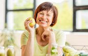 Woman is smiling with apple in hand