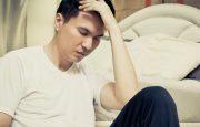 A man is sitting upright in a hospital bed