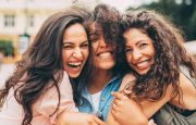 Three best friends hugging each other in the city.